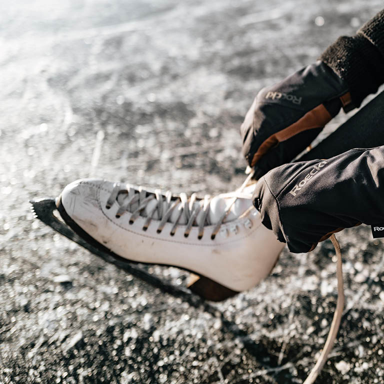 Eine Person die sich die Eislaufschuhe bindet