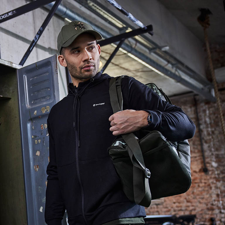 Ein Mann der mit seiner Sporttasche ins Fitnessstudio geht