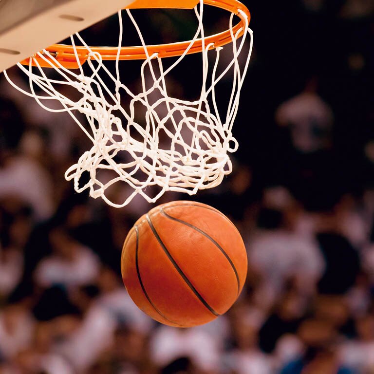 Zu sehen ist ein basketball der durch einen Basketballkorb fliegt
