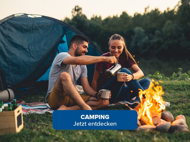 Ein Mann und eine Frau sitzen vor einem Lagerfeuer beim Camping Camping Jetzt Entdecken