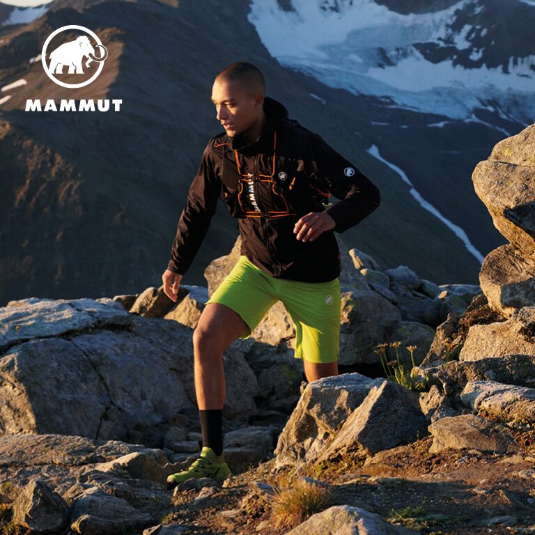 Mammut Ein Mann der in mammut Wanderbekleidung auf den Berg hinauf steigt