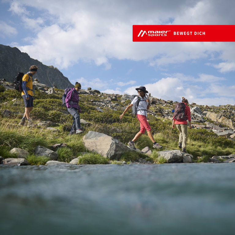 Maier Sports Bewegt Dich Eine Gruppe geht in den Bergen an einem See vorbei