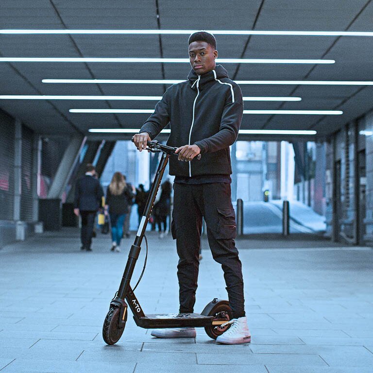 Man sieht einen Mann der mit einem Scooter in der U-Bahn steht